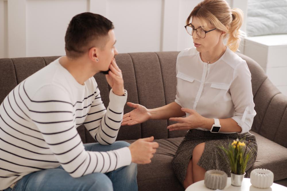 Hombre y mujer sentados en un sofá hablando